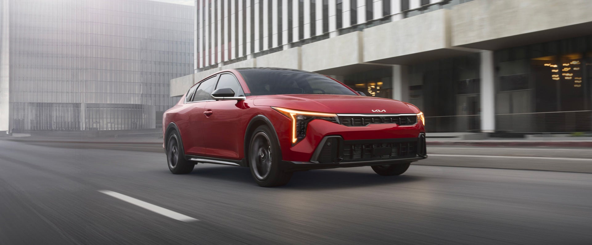 2026 Kia K4 sedan shown from the front three-quarter angle on a city street